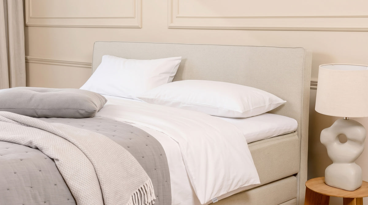 Boxspringbett mit Stauraum, Klassik Armlehne und weißer Bettwaesche.