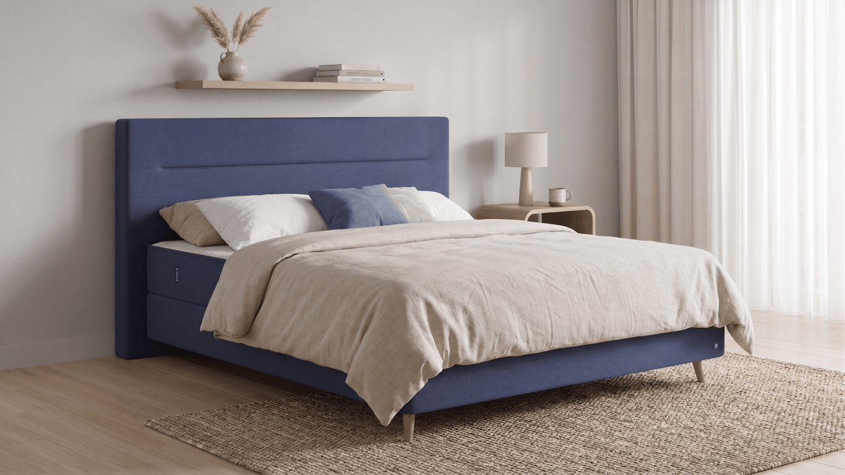 Bruno Boxspringbett mit Linea-Kopfteil, in Blau, Winkelansicht, im Wohnraum, mit Füßen aus nordischer Eiche