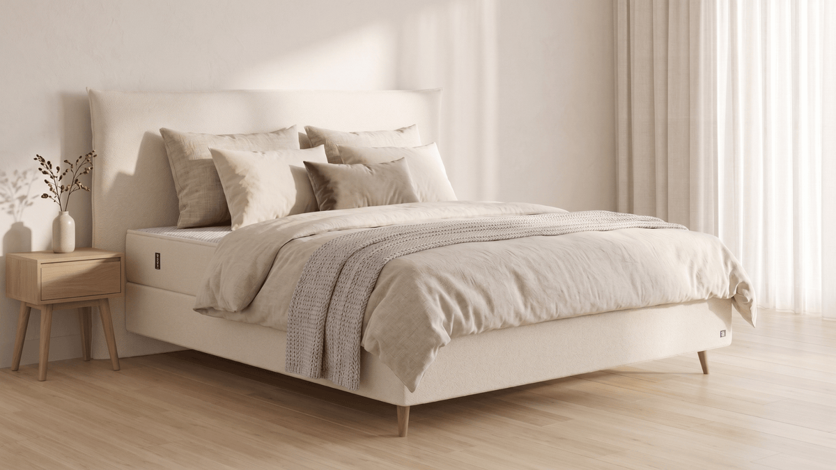 Bruno Boxspringbett mit Pillow-Kopfteil, in Beige, Winkelansicht, im Wohnraum, mit Füßen aus nordischer Eiche